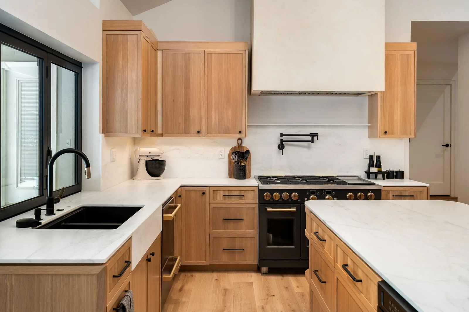Custom oak kitchen with marble counters and matte black fixtures